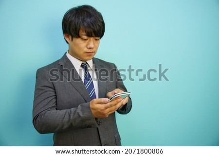 Asian man operating a mobile phone