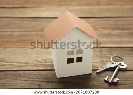 Paper house and key on grey background with copy space. Top view