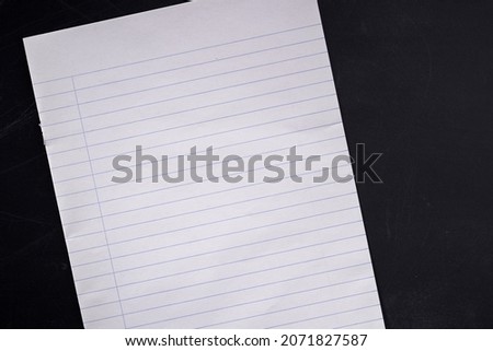 blank  lined notepad on blackboard