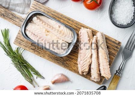 Canned Mackerel Fillets in Tin set, on wooden cutting board, on white background with herbs and ingredients, top view flat lay Royalty-Free Stock Photo #2071835708
