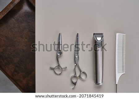 Heritage and modern scissors and trimmer, instruments in barbershop. Professional hairdressing tools on gray table. Hairdressing devices. Selective focus on scissors