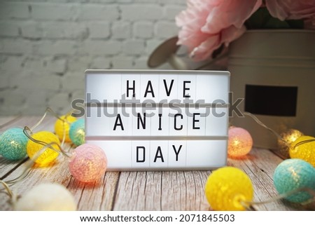 Have a nice day text on lightbox on wooden background