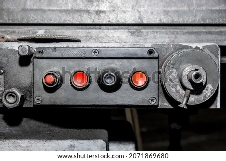 Dirty and old control panel with red buttons system for industrial machine use in the factory.