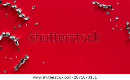 close up top view group of silver color of rolling ribbon and confetti on red background with copy space for merry christmas, happy new year ,festival ,birthday and anniversary, concept design	
