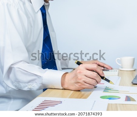 executive ​work and point on document data graph on working desk by pen, professional businessman busy work on the business data graph