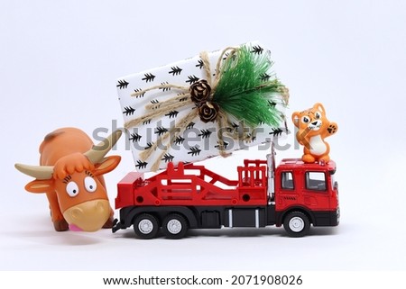 Toy tiger and bull on a red car, the concept of the outgoing year of the bull, and the upcoming year of the tiger, 2022 on a red background