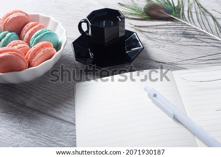 Coffee, macaroons and cream with a good morning card on a white table