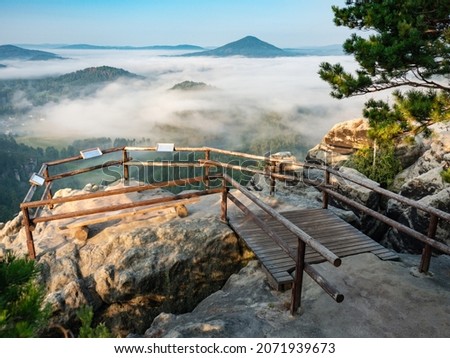 Tourist view platform with engraved map on Vilemina rock. Popular view point above forest landscape of Bohemia Switzerland national park in North of Czech Republic Royalty-Free Stock Photo #2071939673
