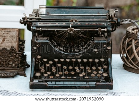 Close-up of Vintage old fashioned typewriter machine Underwood on desk next to window in light white shabby chic vintage country cottage interior room
