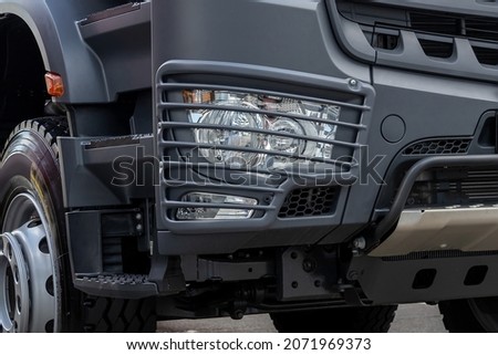 Fragment of the cab of a new truck. Truck parts - headlight, protection grill, wheels, bumper and footrests Royalty-Free Stock Photo #2071969373