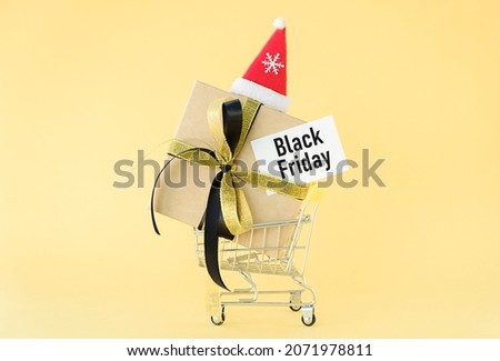 Holiday gift, Black Friday concept with gift box in a metal shopping trolley, basket on yellow color