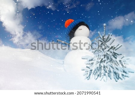 winter landscape with a snowman and a snow-covered Christmas tree on a blue sky background