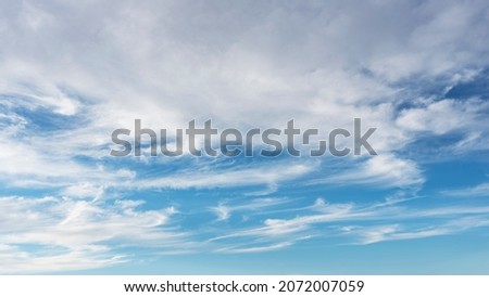 Wispy white clouds and blue sky suitable for background
