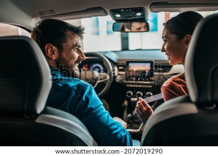 Beautiful young couple at car showroom choosing a new car to buy. Royalty-Free Stock Photo #2072019290