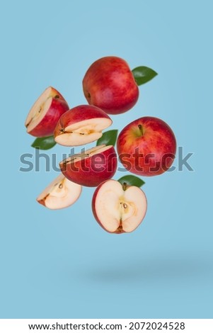Minimal fruit concept with fresh sliced and whole apple floating in the air isolated on blue background. Vitamins, healthy diet concept. Creative concept with flying fruits.