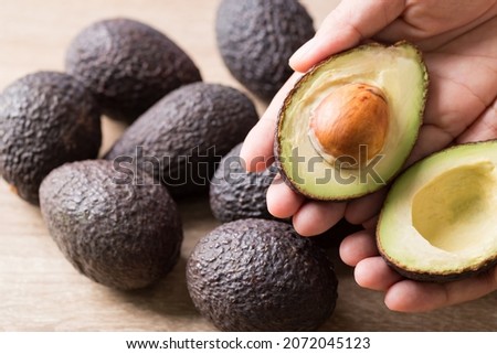 Ripe hass avocado fruit in hand ready to eating, Healthy fruit Royalty-Free Stock Photo #2072045123