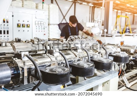 Workshop with extruders for producing plastic pipes. High speed extrusion line of water suppply and gas pipe. Manufacturing facility. Royalty-Free Stock Photo #2072045690
