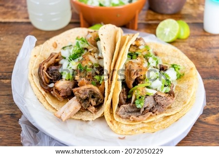 Beef tacos with onion, cilantro, sauces and a double tortilla.