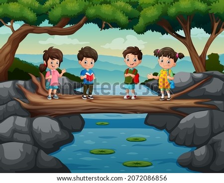 Cute kids cross the river on the tree trunk bridge
