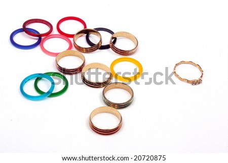 A metaphorical picture of a unique golden ring standing out from a group of colorful rings, on a white background. This image depicts leadership or uniqueness.