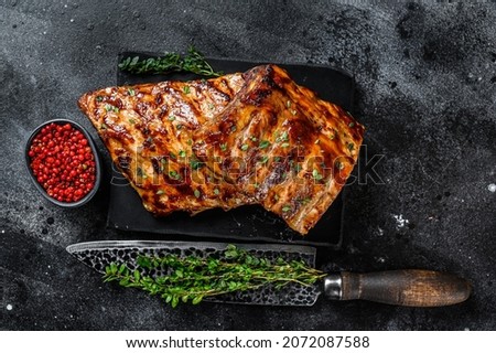 Barbecue pork rack spare ribs on a marble board. Black background. Top view Royalty-Free Stock Photo #2072087588