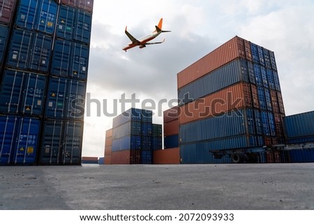 Freight airplane flying above overseas shipping container . Logistics supply chain management and international goods export concept . Royalty-Free Stock Photo #2072093933