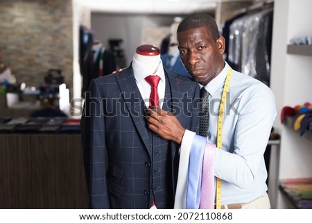 African-american man buyer in shirt choosing colored tie in the dress shop. High quality photo