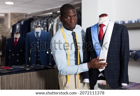 African-american man buyer in shirt choosing colored tie in the dress shop. High quality photo