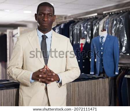 African-american man choosing casual jacket in fashion store. High quality photo