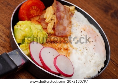Breakfast bread with fried egg, bacon, pepper, avocado, tomato plate background