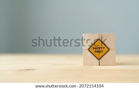 Safety symbols and first signs, work safety, caution work hazards, danger surveillance, zero accident concept on wooden cubes with beautiful  grey background and copy space. Safety banner. Royalty-Free Stock Photo #2072154104