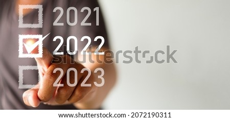 Hand selecting year 2022 on white background with copyspace use for happy new year concept.