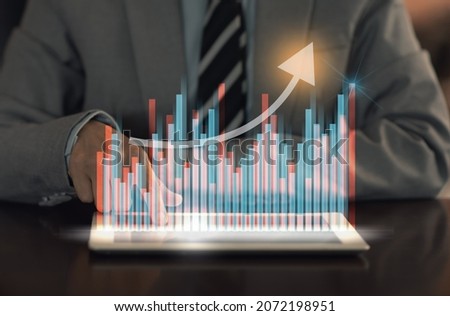 Investment technology concept. Investor using digital tablet to show investment portfolio with index stock market and chart with uptrend stock market graph. Royalty-Free Stock Photo #2072198951
