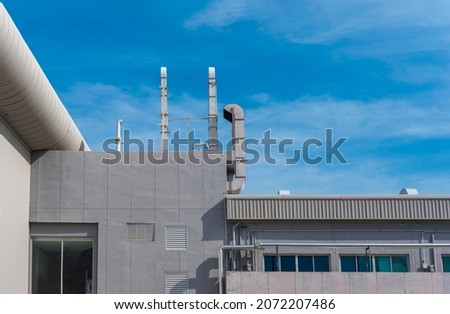 Pictures buildings minimal style consist of concrete wall window and ventilation pipe with blue sky background.