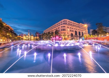 A lotus-shaped fountain with nice lights on Nguyen Hue street walking in front of Ho Chi Minh statue and Ho Chi Minh People's Committee, Saigon, Ho Chi Minh City, Vietnam. 