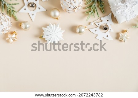 Christmas beige background with stylish decorations, balls, stars, gift box. Boho style. Flat lay, top view. 