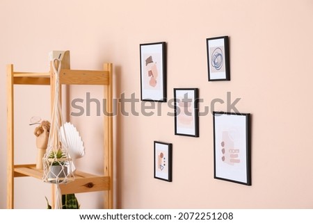 Different pictures hanging on color wall in room