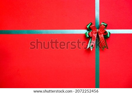 Christmas background with green ribbon and copy space. Decorative gift box. Top view shot