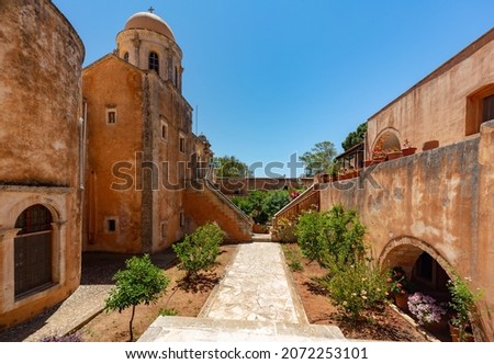 Beautiful picture of Governeto Christian orthodox monastery near Chania in Crete , Greece ,plants, palm trees , and old yellow stones