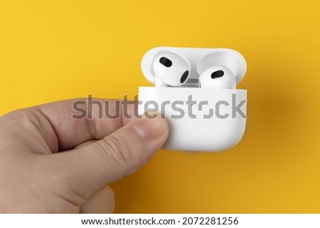 White wireless headphones on a yellow background. Bright background