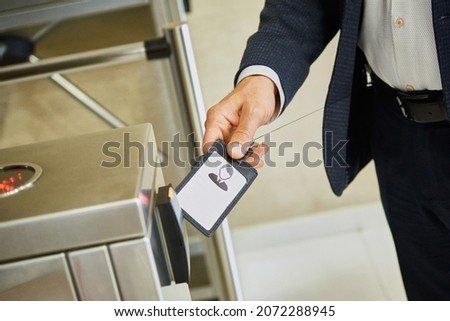 A man uses an electronic pass to pass through the turnstile. Ensuring the security of the company. Electronic document