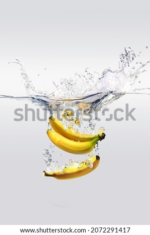 3 bananas being washed with water
