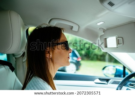 beautiful middle aged young woman driving serious wearing sunglasses. jam. routine