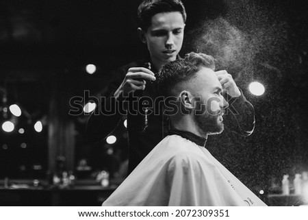 Young man at barbershop trimming hair Royalty-Free Stock Photo #2072309351
