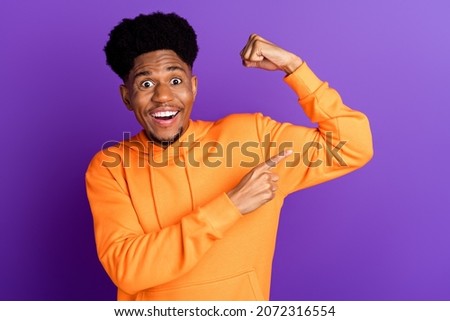 Photo of brunette young dark skin man wear sweater point finger biceps excited isolated on purple color background