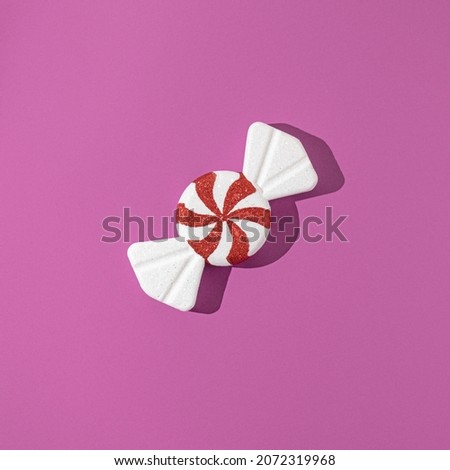 Christmas candies on purple background. Flat lay. Minimal composition. New Year concept.