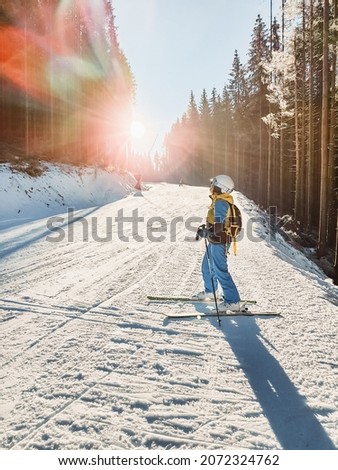 woman in equipment at ski slope sun rays go through slope Royalty-Free Stock Photo #2072324762