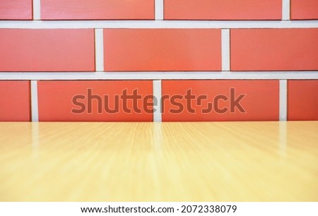 
Red-orange brick wall, wooden table floor