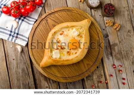 ajara Khachapuri with cheese, egg and butter, georgian kitchen on wooden table top view Royalty-Free Stock Photo #2072341739