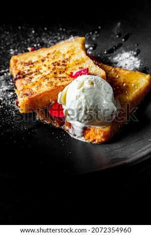french toast with ice cream on black plate